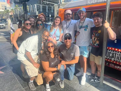 Film Freak Tours guests posing on the Hollywood Walk of Fame next to the tour van